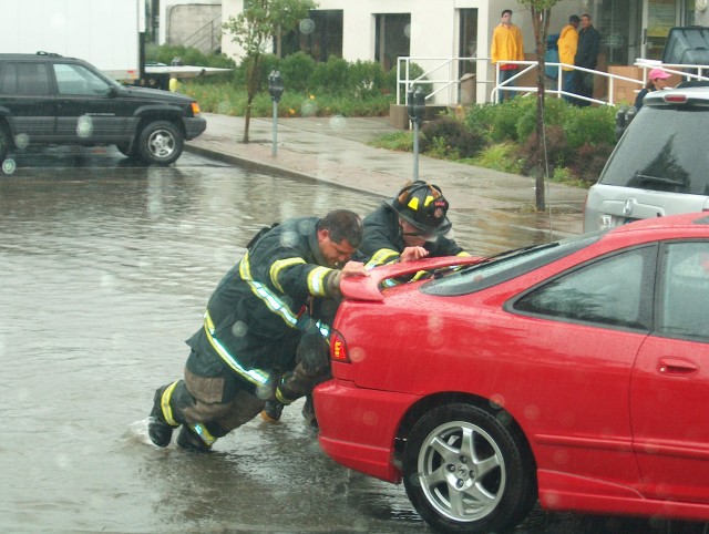 David Hughes and Brian Pieragostini help remove a car from the rising waters of Hurricane Charlie