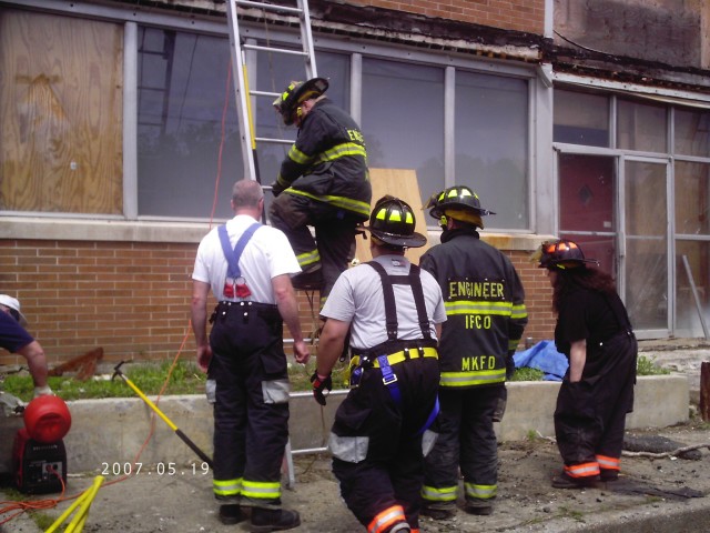 Members of the &quot;Hooks&quot; working with members of the Independents on raising their 35-foot ground ladder.