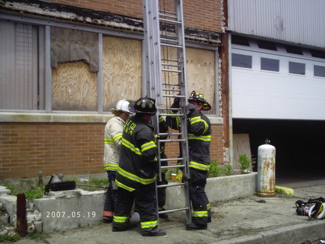 Chief Bueti works with members of I.F.CO. on raising the 35-foot ground ladder.