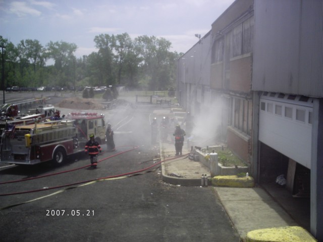 Mount Kisco Department Drill at Grand Union warehouse. Smoke pushes from structure as crews advance. 
