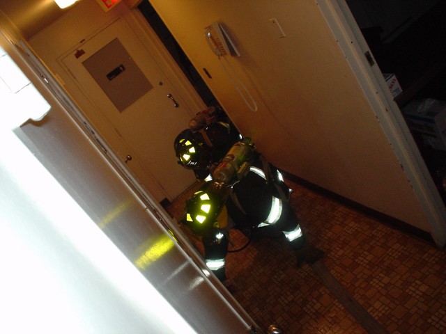 With blackened face masks, members train on following a hose line in search of a downed fireman