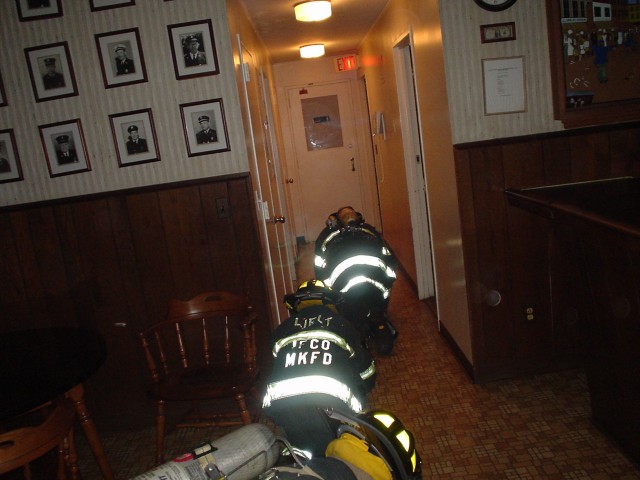 After locating a downed fireman, members follow the hose line out to safety