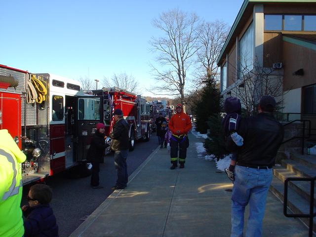 Fire truck riders find their spots on the trucks. X-mas fire truck rides. (12/12/09)